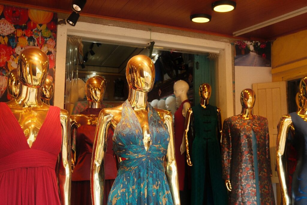 Golden mannequins display elegant dresses in a boutique.