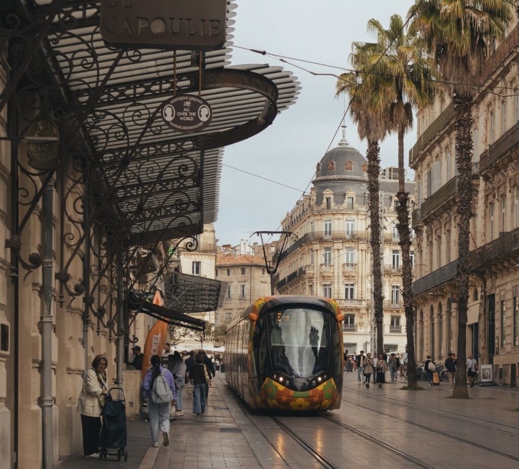 A modern tram travels down a historic european street.