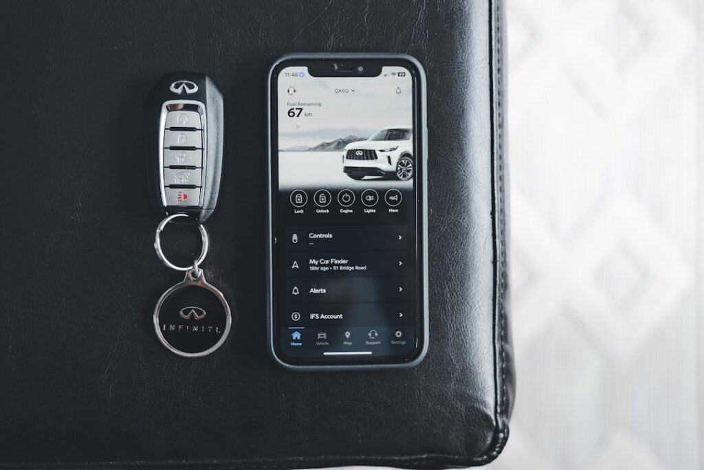 a cell phone sitting next to a car keychain