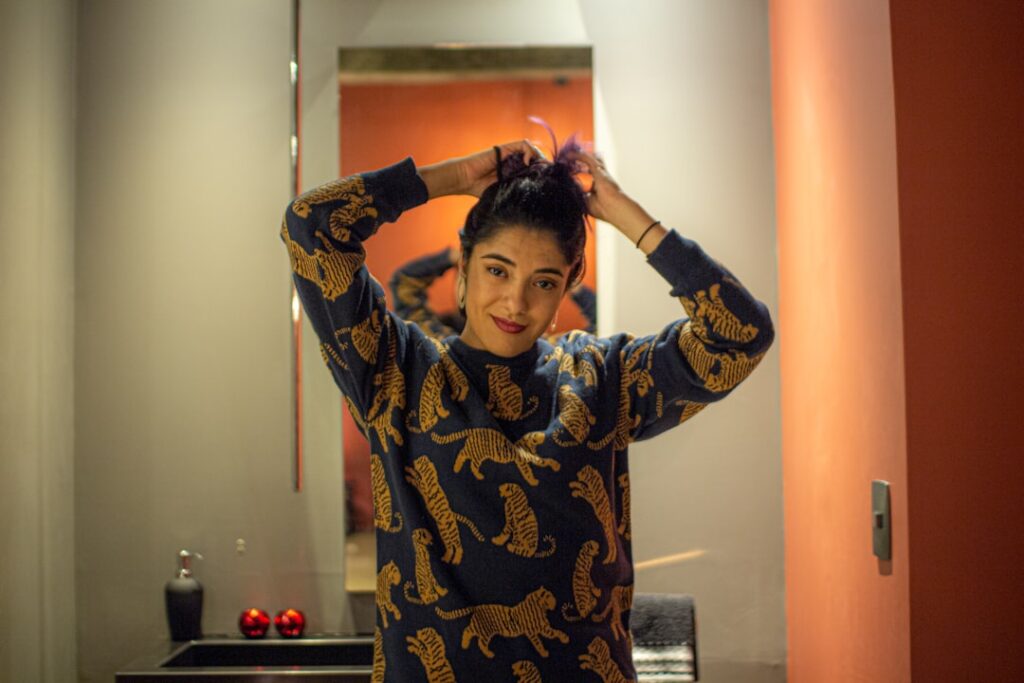 a woman standing in front of a bathroom mirror