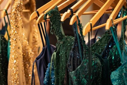 Sparkling dresses are hanging on a clothes rack.