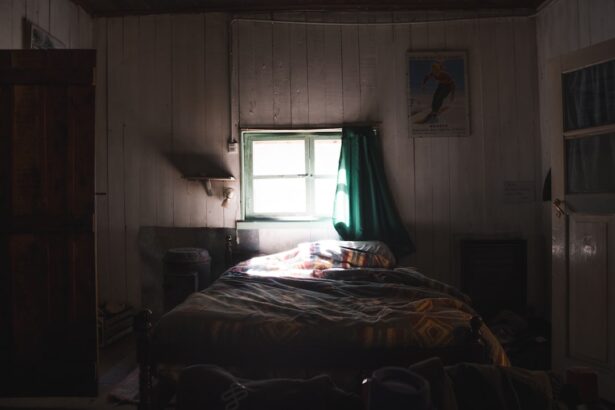 Dimly lit bedroom with a bed and window.
