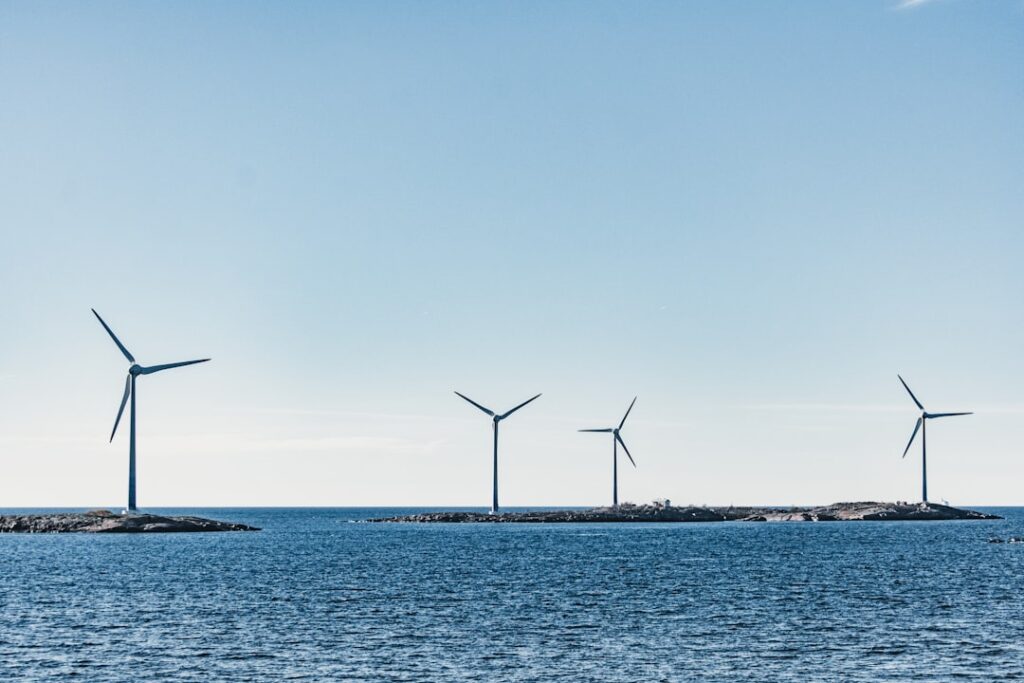 wind turbines on blue sea under blue sky during daytime