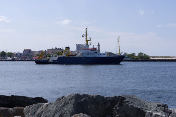 black ship on sea under white clouds during daytime