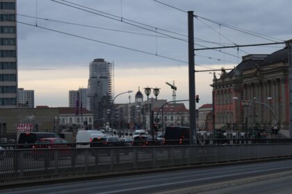 a city street filled with lots of traffic next to tall buildings