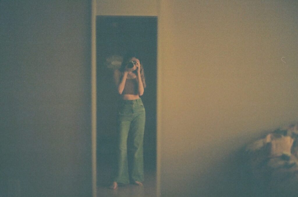 a woman taking a picture of herself in a mirror