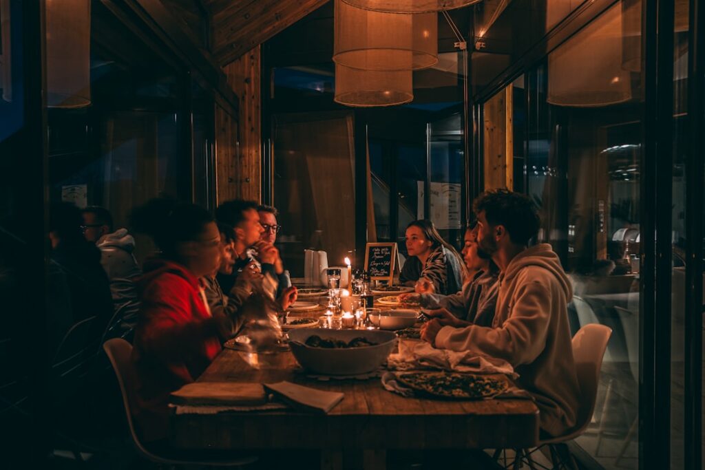 People enjoying a candlelit dinner at a dimly lit restaurant.