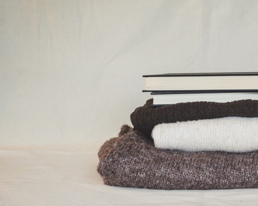 A stack of folded books sitting on top of a pile of blankets