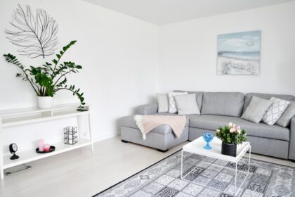 Modern living room with gray sectional and plants.