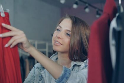 Woman browses clothing on a clothing rack.