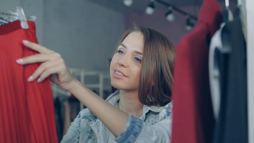 Woman browses clothing on a clothing rack.