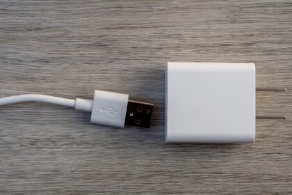 White usb charger and cable on wooden surface