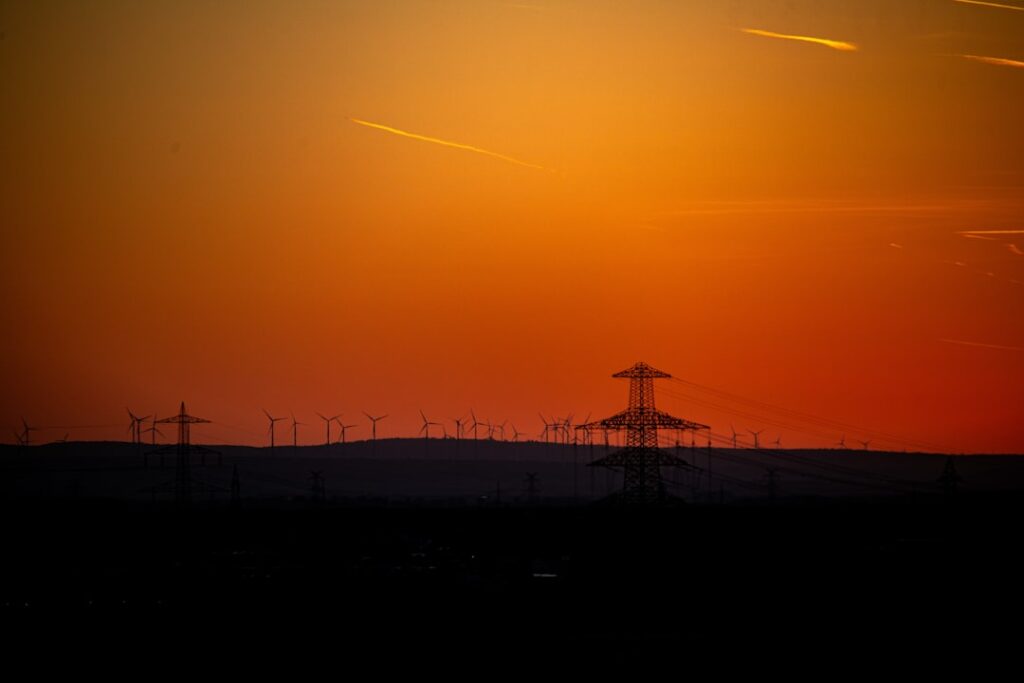 Sunset over a field with power lines