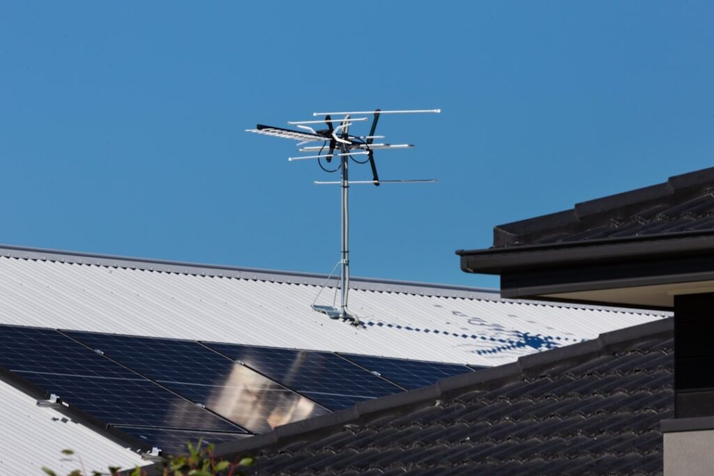 A television antenna stands tall against a clear blue sky.