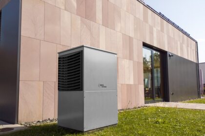 Modern outdoor heat pump unit next to building