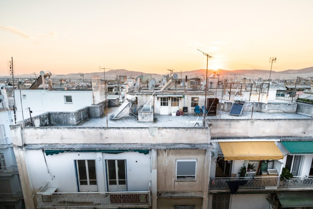 Rooftops of buildings against a hazy sunset sky