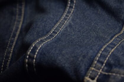 Close-up of blue denim fabric with white stitching