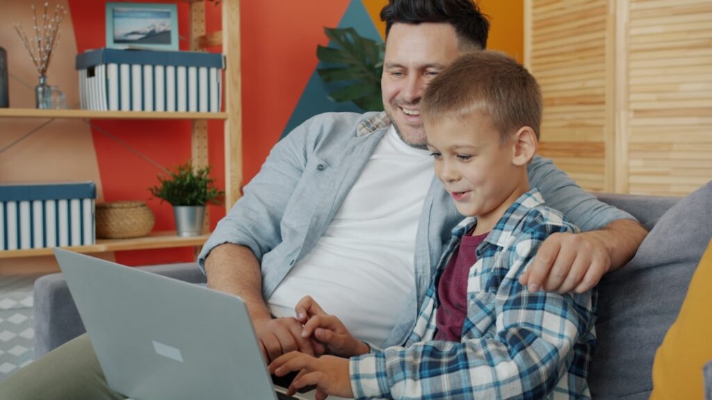 Father and son looking at laptop together
