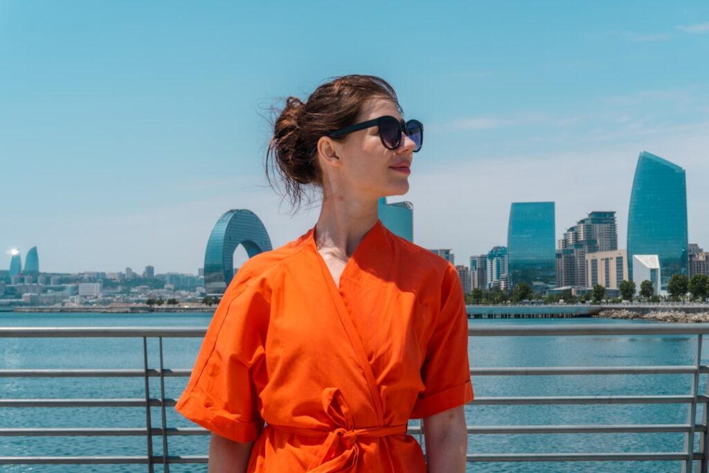 Woman in orange dress with city skyline background