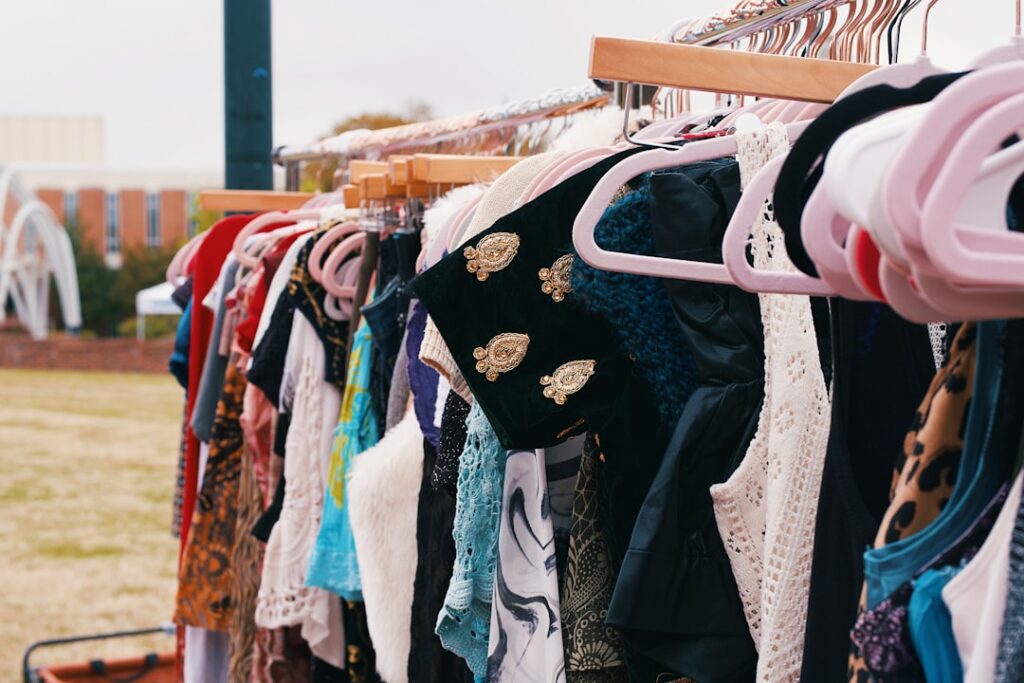 Clothes are hanging on a rack at a market.