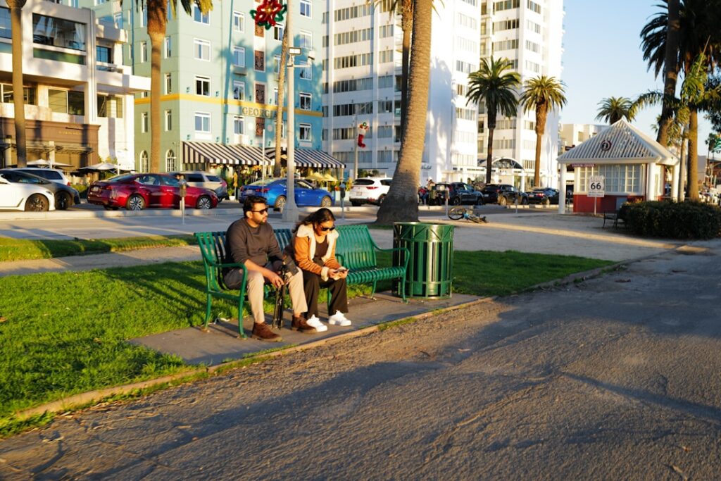 Couple sitting on park bench with buildings behind