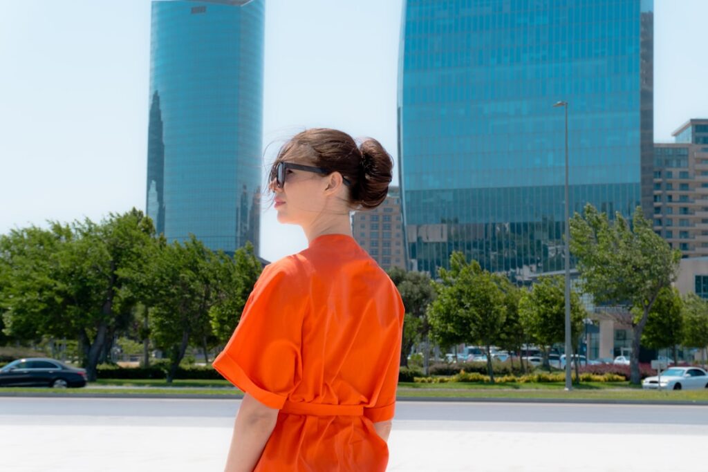 Woman in orange dress with modern city buildings
