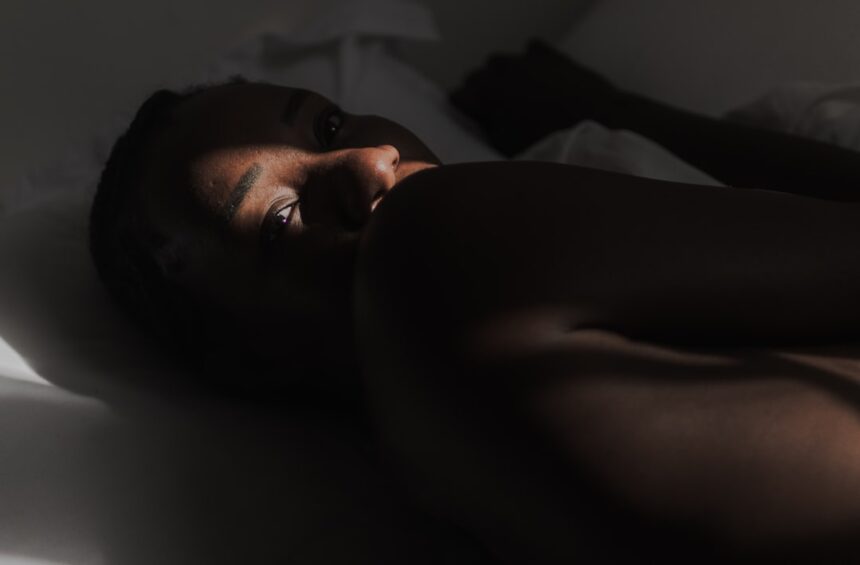 A woman laying on a bed with her eyes closed