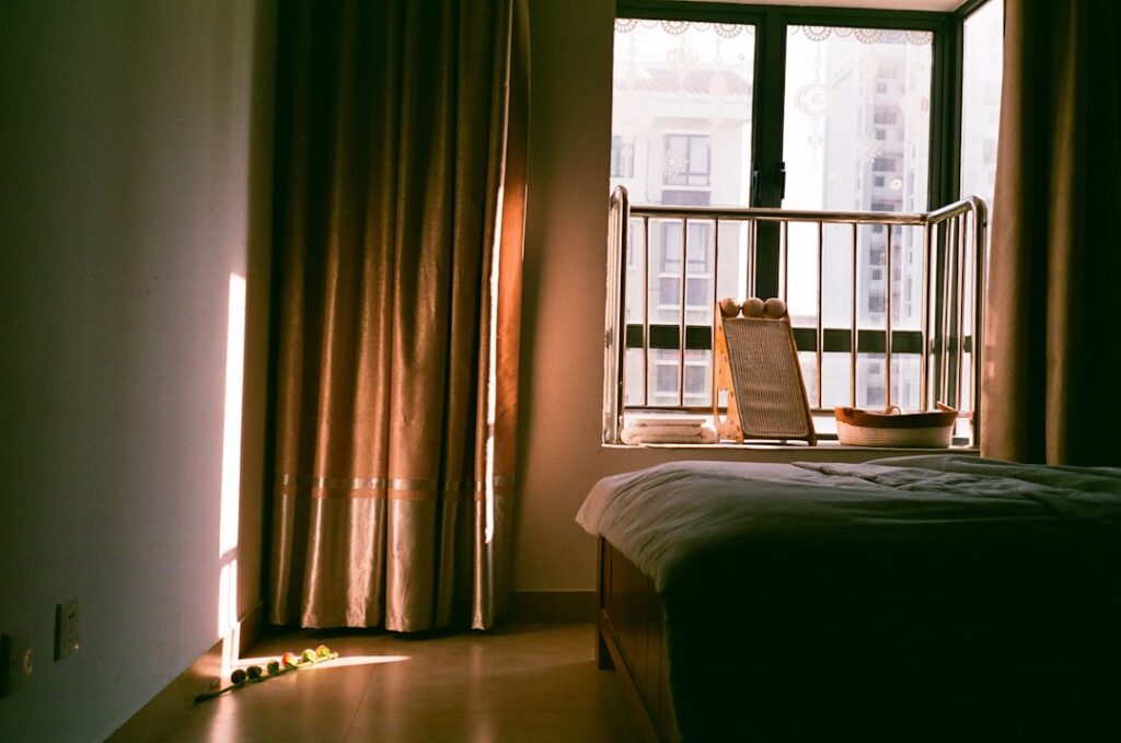 Bedroom with sunlight streaming through window curtains