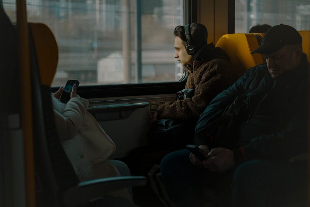 People are seated on a train, looking out.