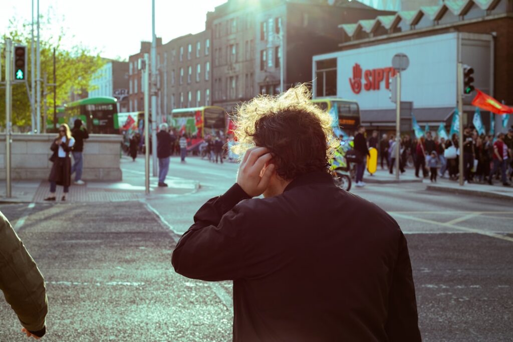 Person on street with sun flare and buildings