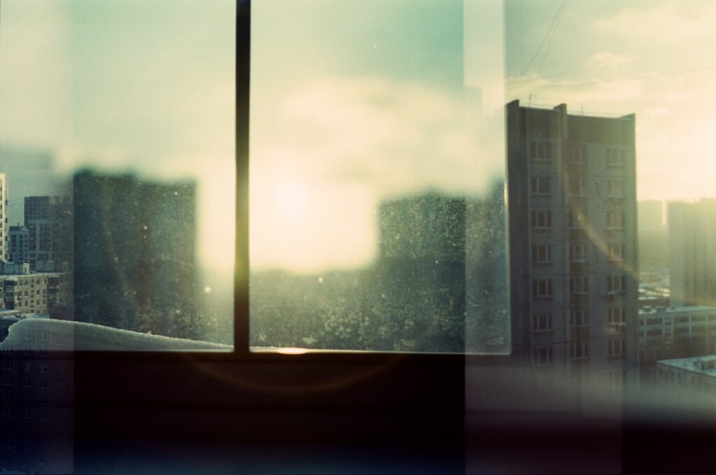 City skyline seen through a window at sunset.