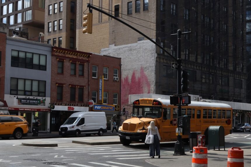 Yellow school bus on a city street corner.