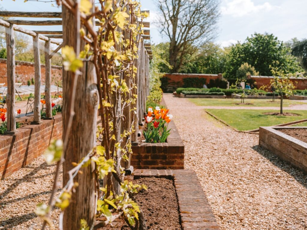 A beautiful garden with a gravel path and flower beds.