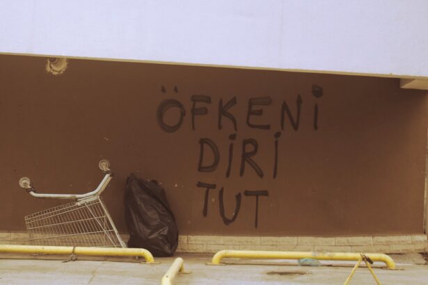 a shopping cart leaning against a wall with graffiti on it