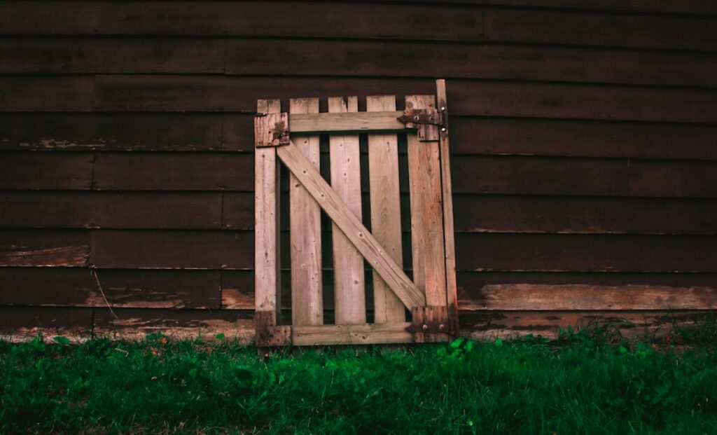 brown wooden fence lean on brown barnhouse during daytime