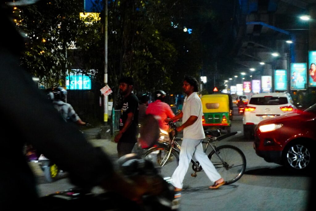 A man crosses a busy street at night.
