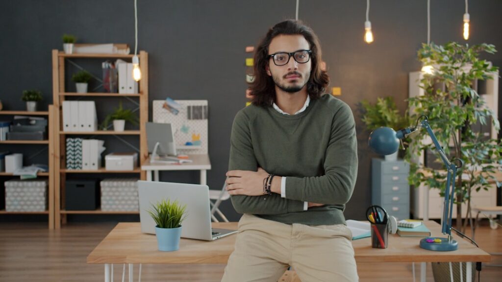 Man with glasses and arms crossed in office.
