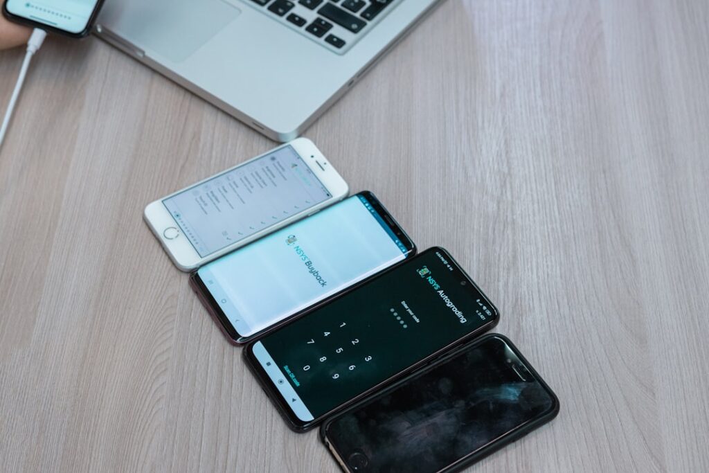 three cell phones sitting next to each other on a table