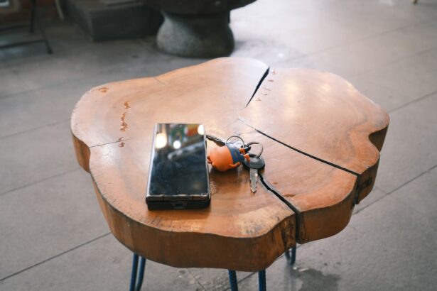 Phone, keys, and an orange ball on a wooden table.