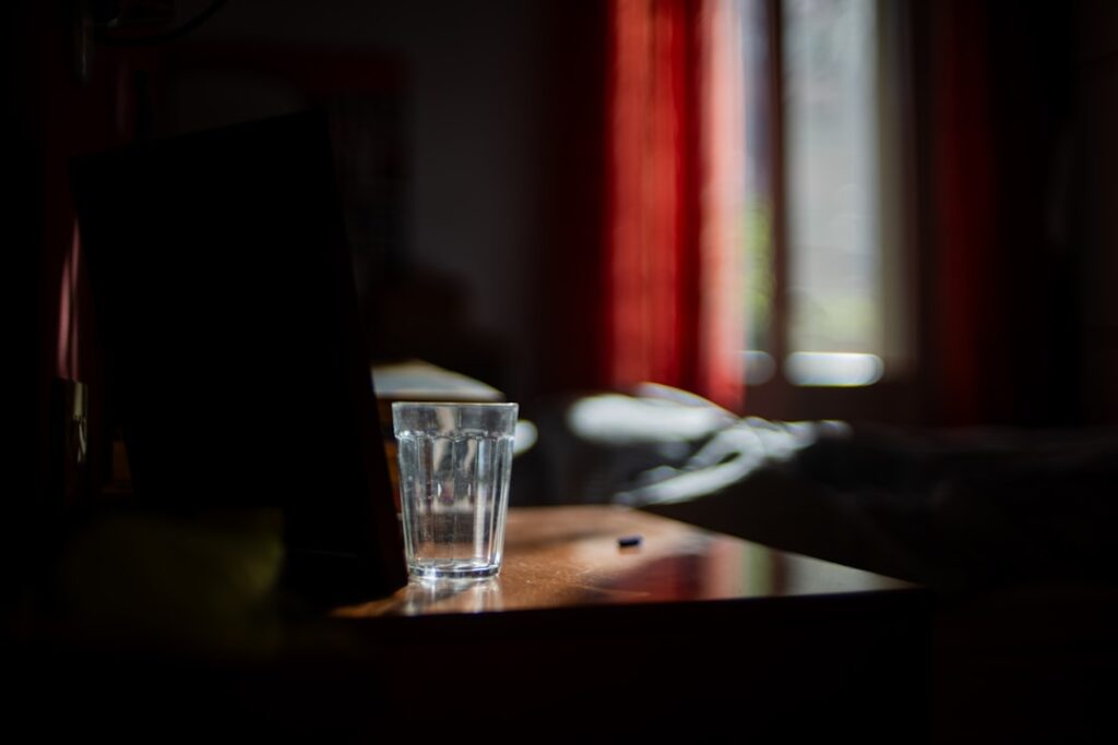 A glass of water on a table in a dark room