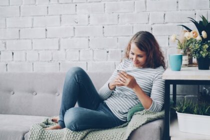Young woman using smartphone on sofa