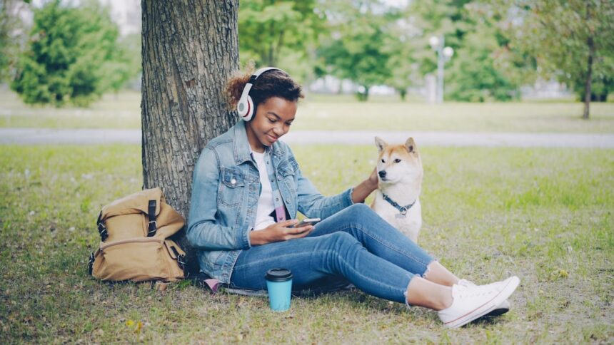 Woman and her dog relax under a tree.