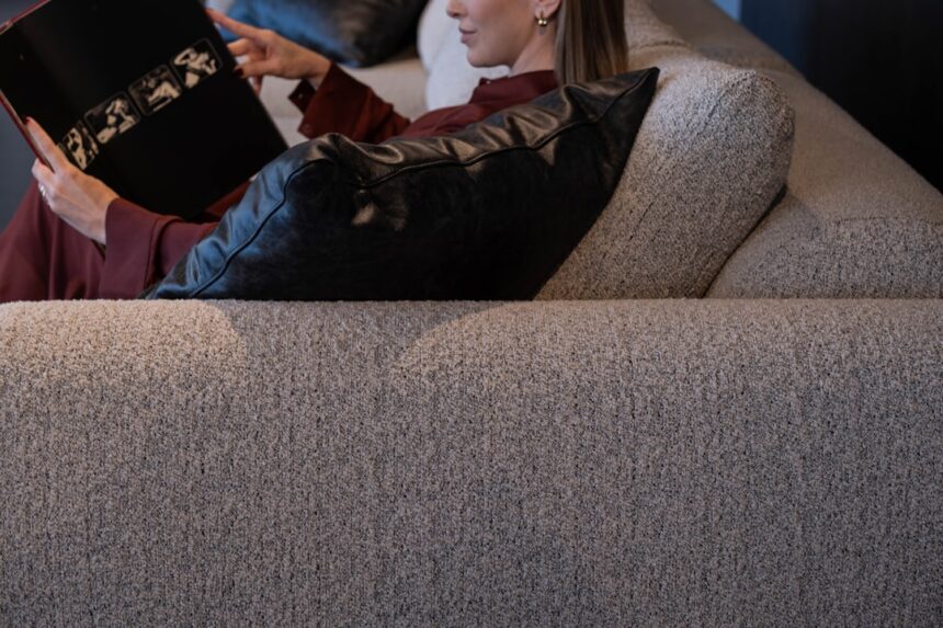 Woman reading a book while relaxing on a couch.