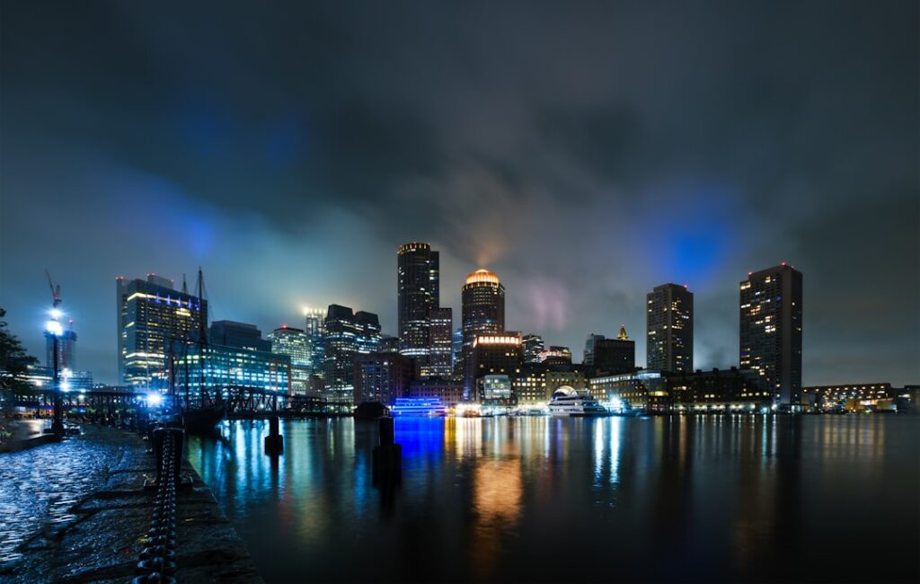 a city skyline at night with lights reflecting in the water