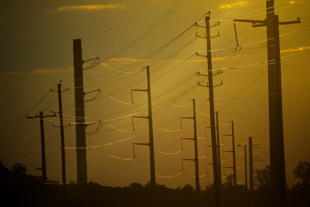 Power lines silhouetted against a hazy sunset sky.