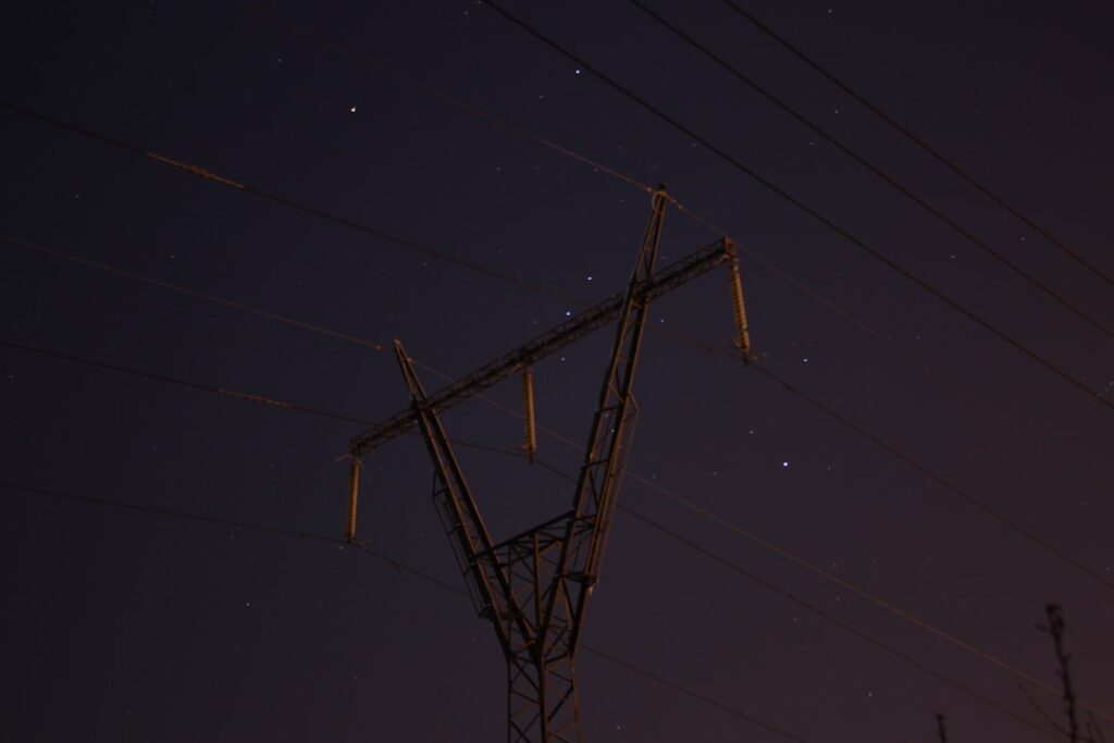 a telephone pole and some power lines at night