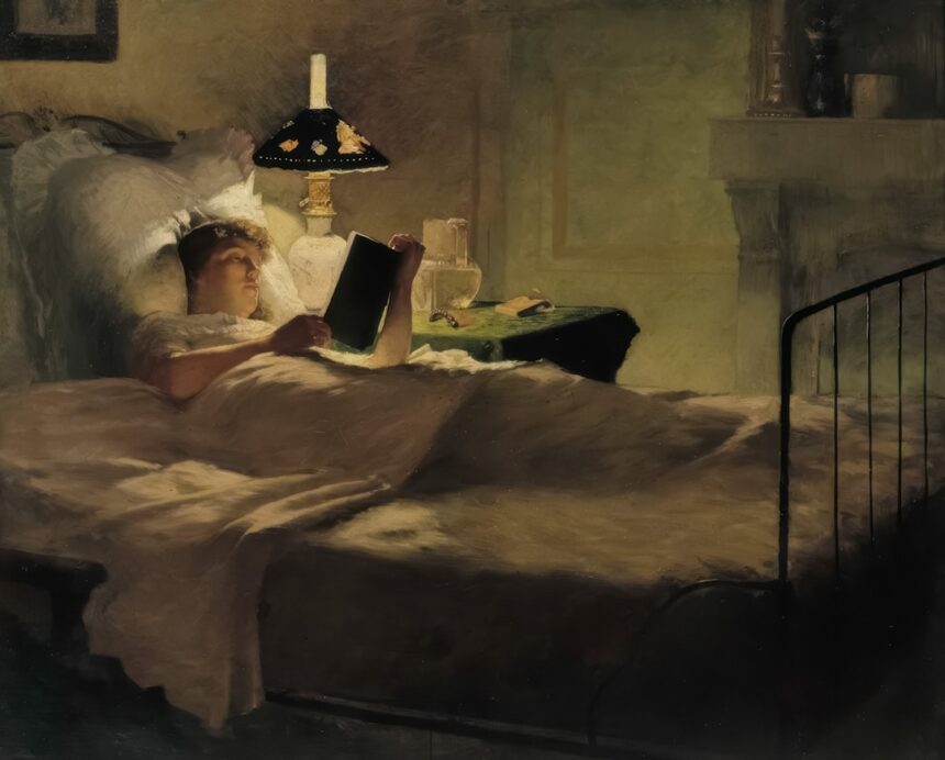 Woman reading in bed by lamplight