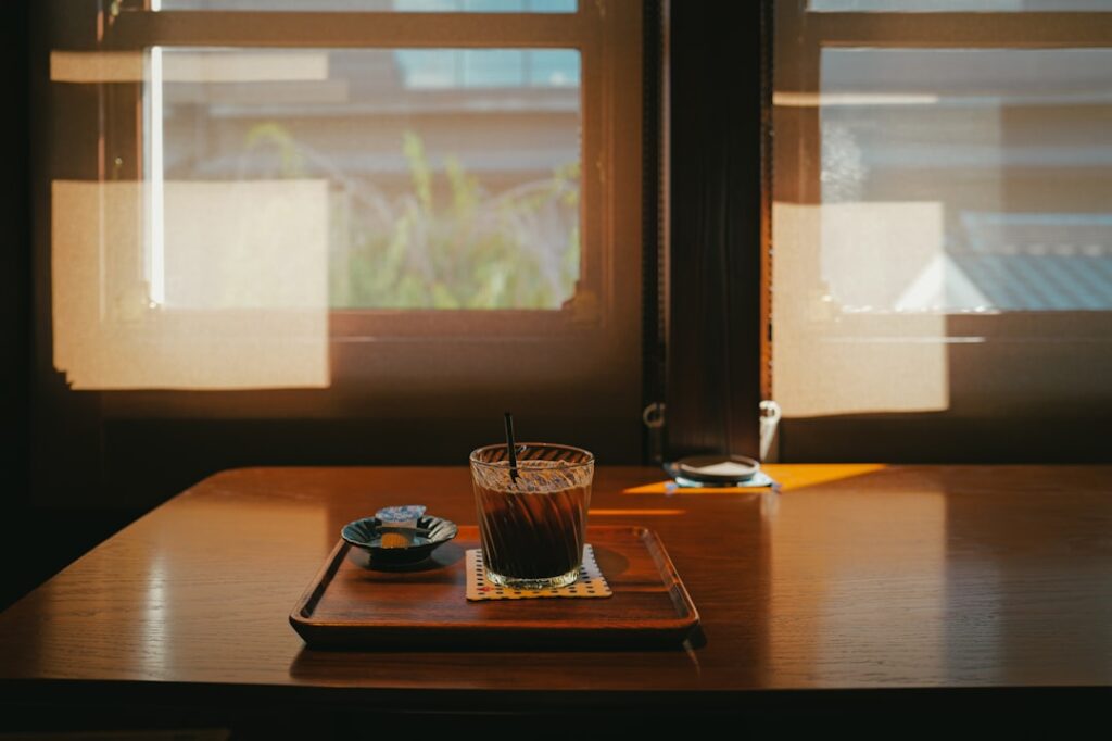 Iced coffee on a wooden table near window