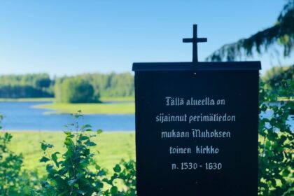 a black sign with a cross on top of it
