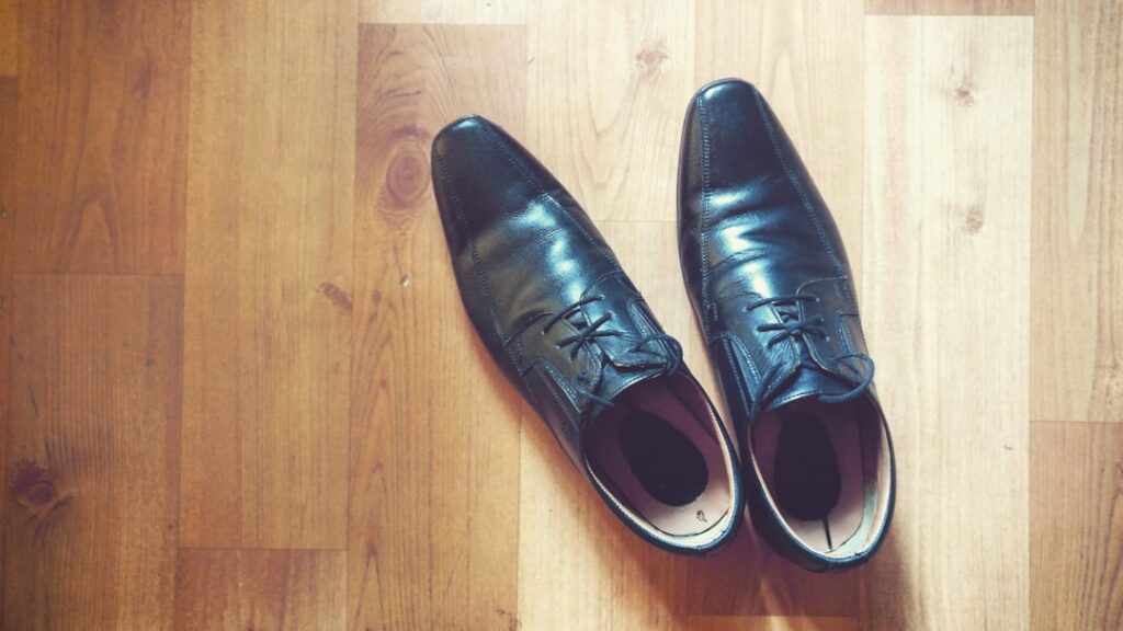 black leather dress shoes on parquet floor